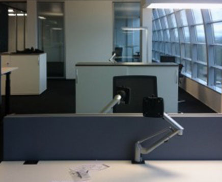 Bild der Büroausstattung des Bürogebäudes Squaire Frankfurt. Klassischer Tisch mit einem schwarzen Stuhl.